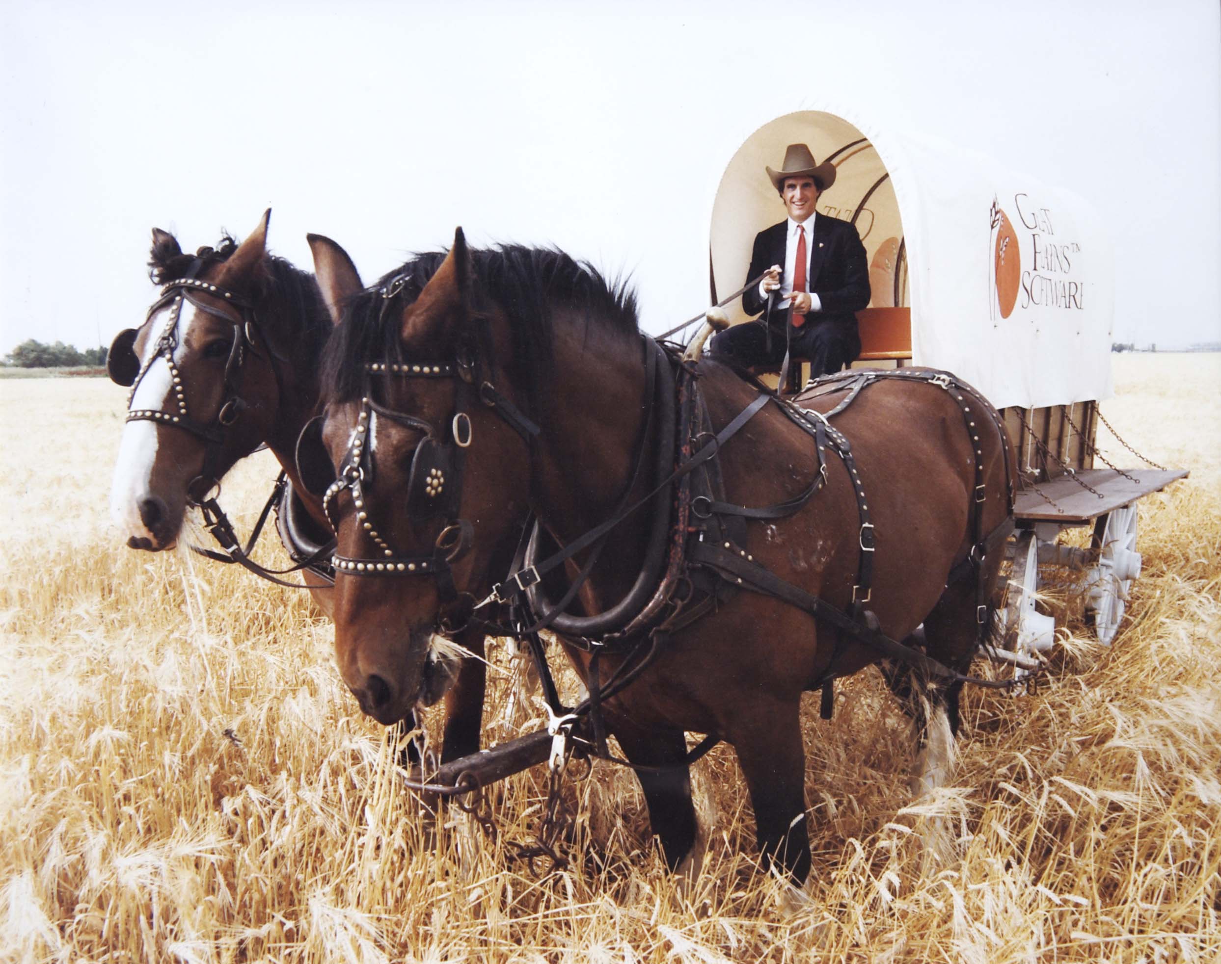 Doug Burgum seated on a covered wagon behind two horses Doug Burgum seated on a covered wagon behind two horses