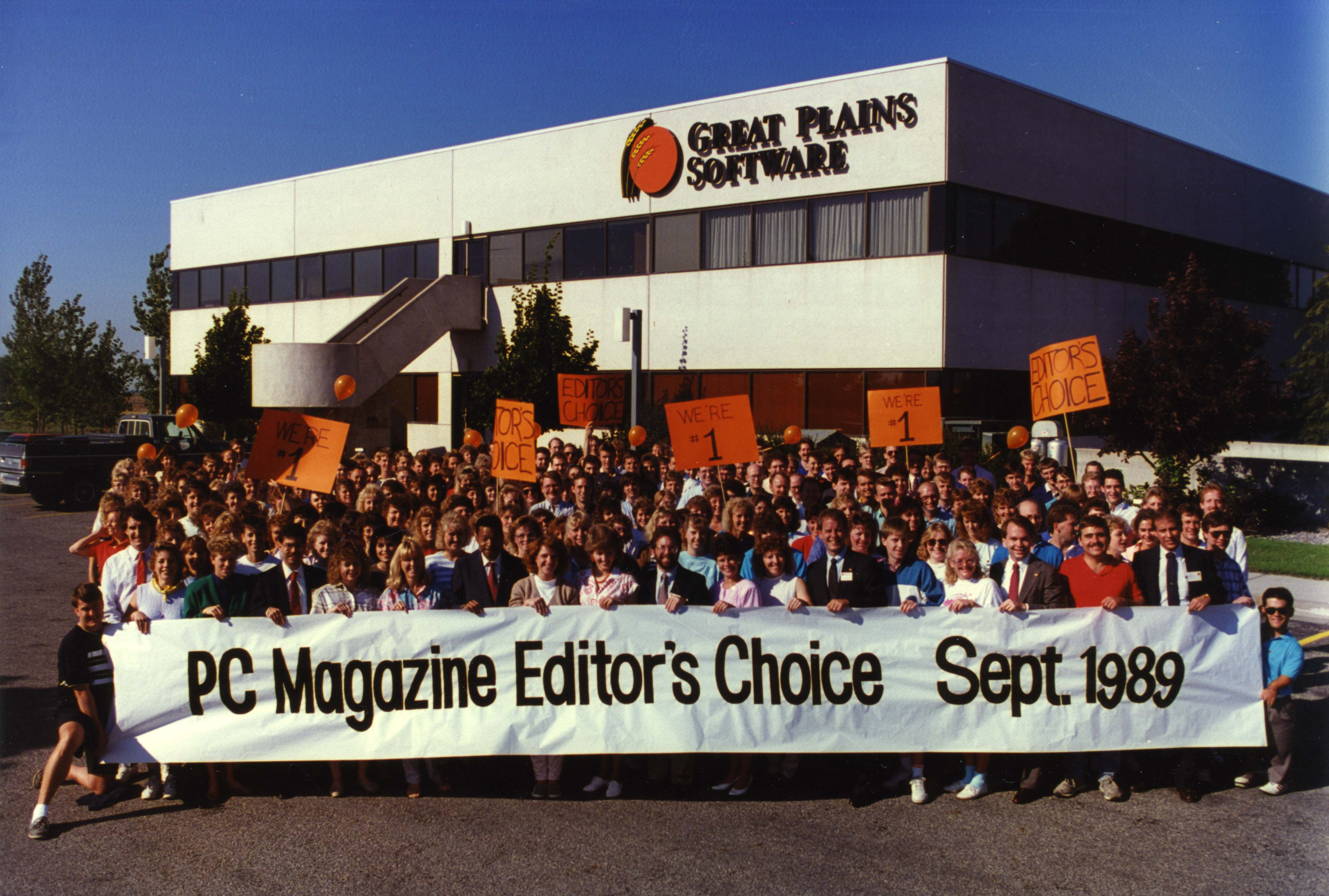 A group of people in front of the Great Plains Software building holding a banner that says "PC Magazine Editor's Choice Sept. 1989" A group of people in front of the Great Plains Software building holding a banner that says "PC Magazine Editor's Choice Sept. 1989"