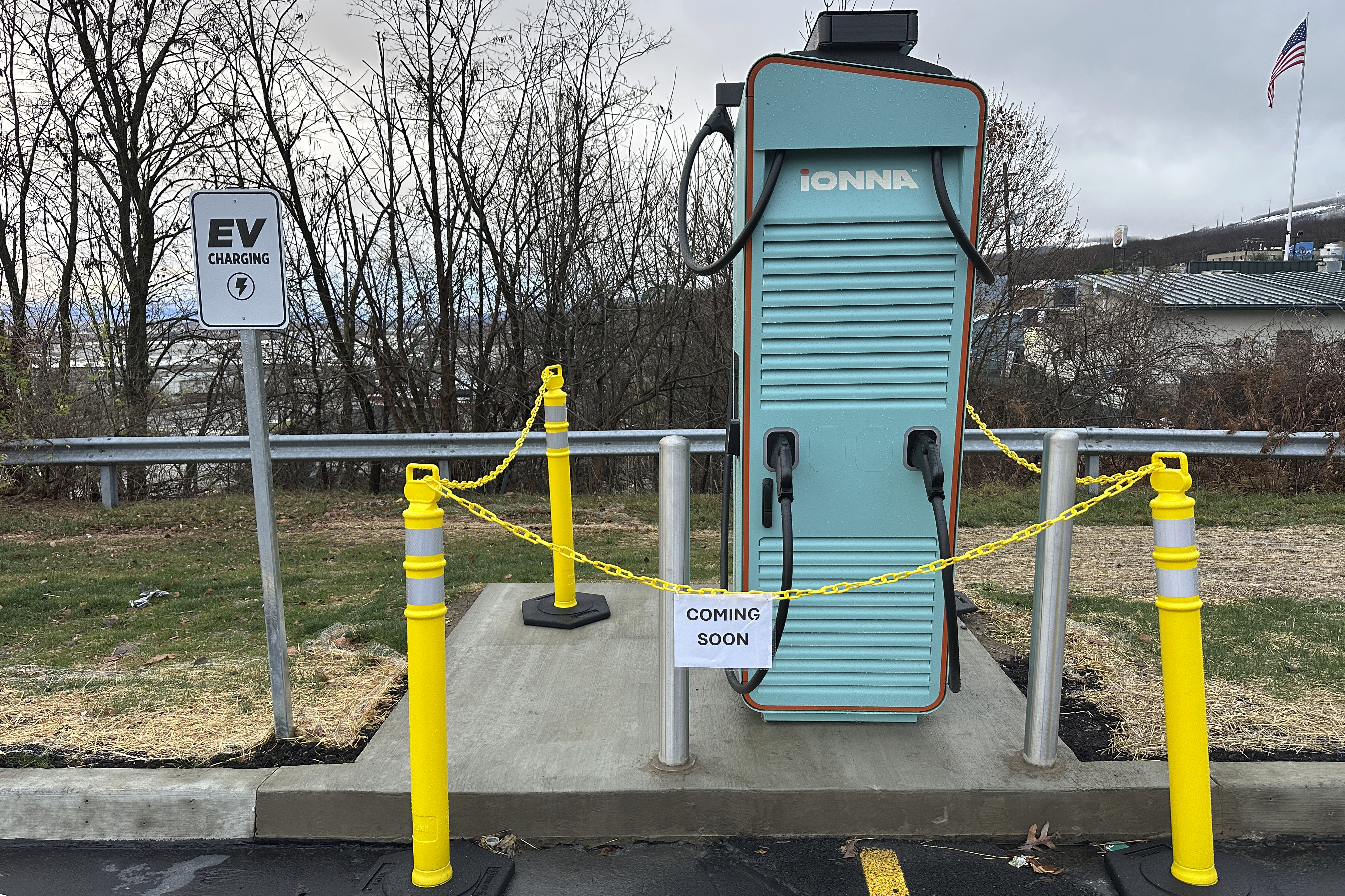 An electric vehicle charging station shown with sign reading: Coming soon. An electric vehicle charging station shown with sign reading: Coming soon.