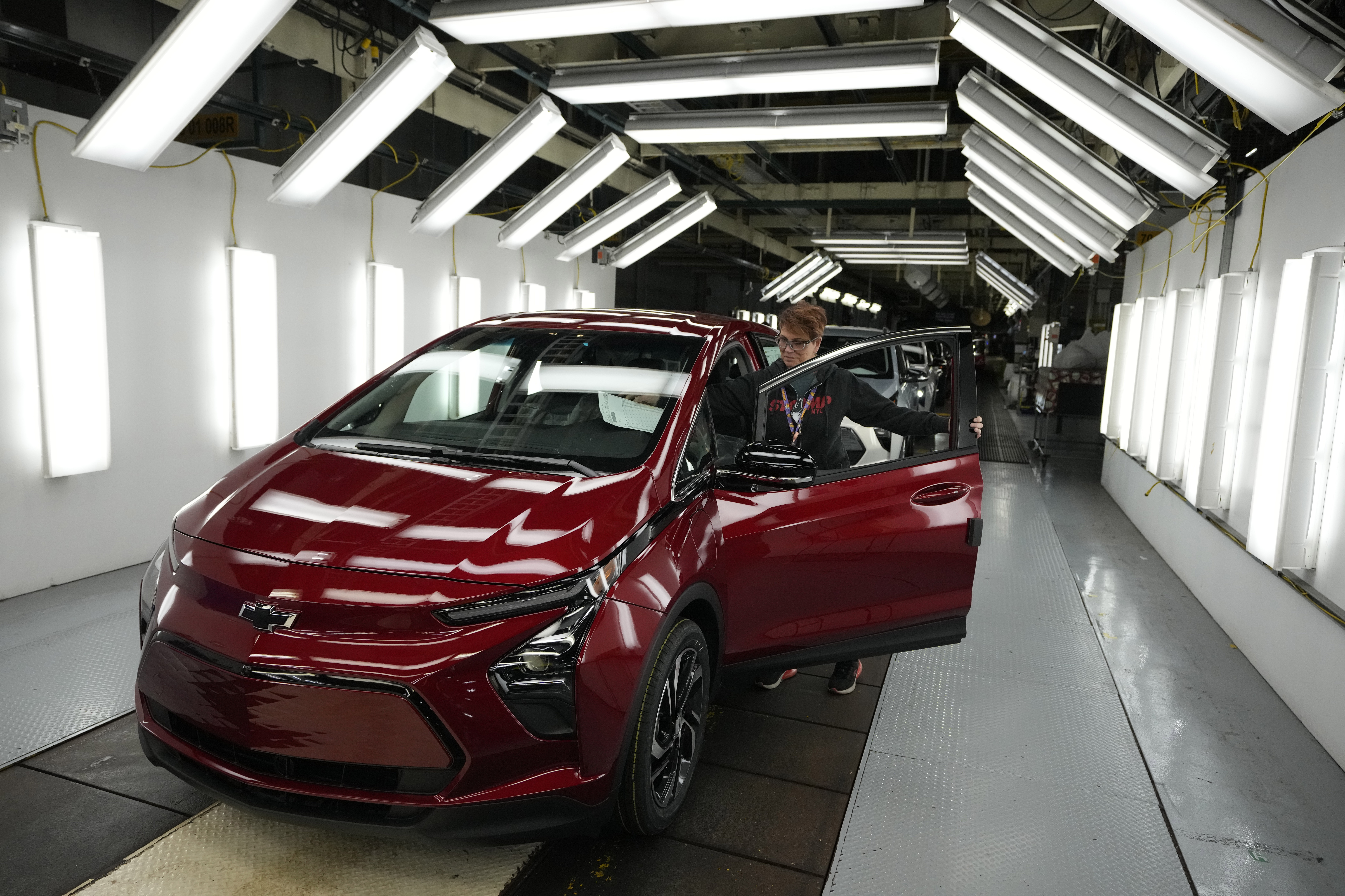Worker Janice DeBono looks over a 2023 Chevrolet Bolt electric car. Worker Janice DeBono looks over a 2023 Chevrolet Bolt electric car.