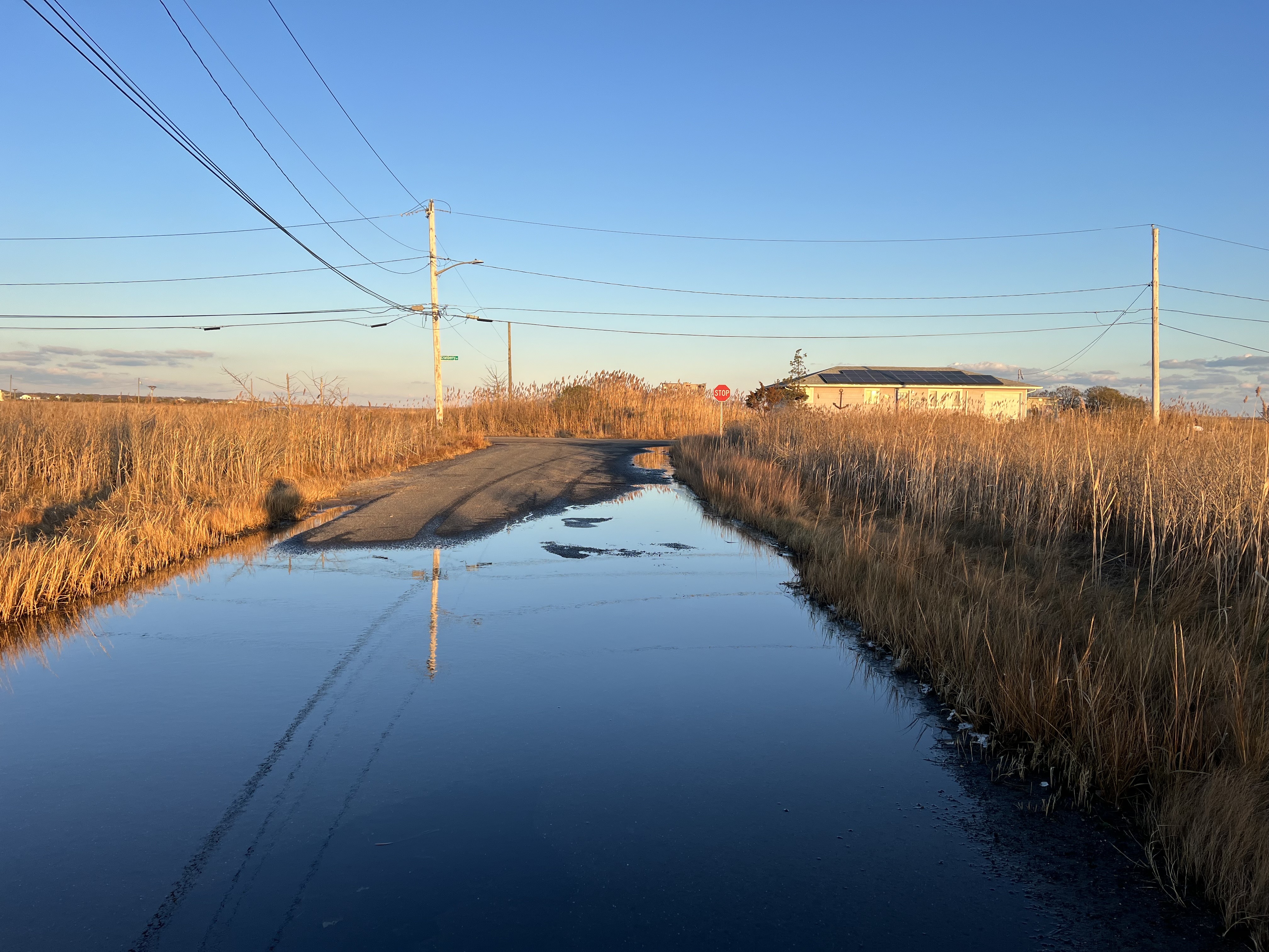 A road near the bay is submerged in a few inches of water. A road near the bay is submerged in a few inches of water.