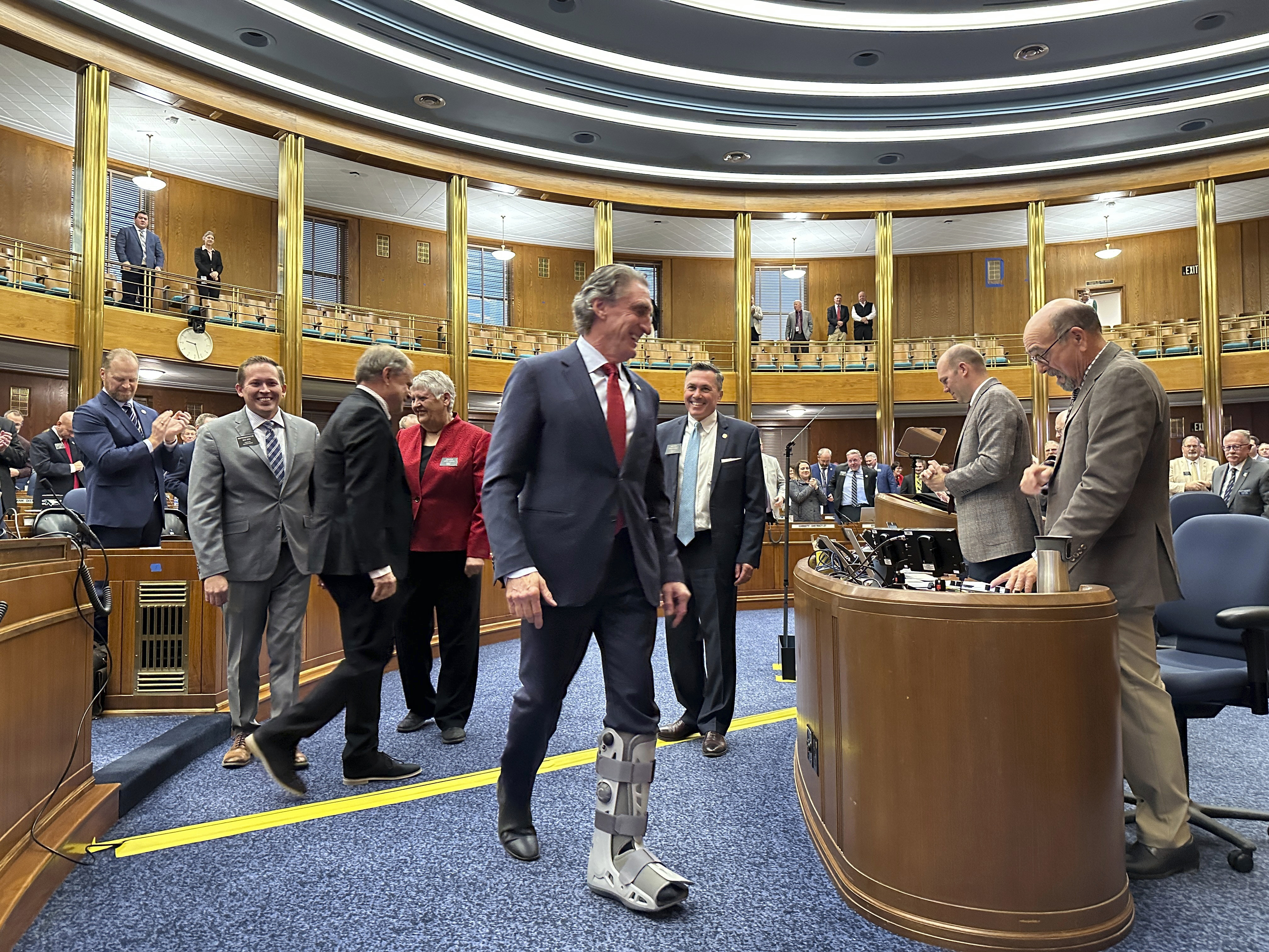 North Dakota Republican Gov. Doug Burgum (center) walks to the rostrum in the state House of Representatives. North Dakota Republican Gov. Doug Burgum (center) walks to the rostrum in the state House of Representatives.